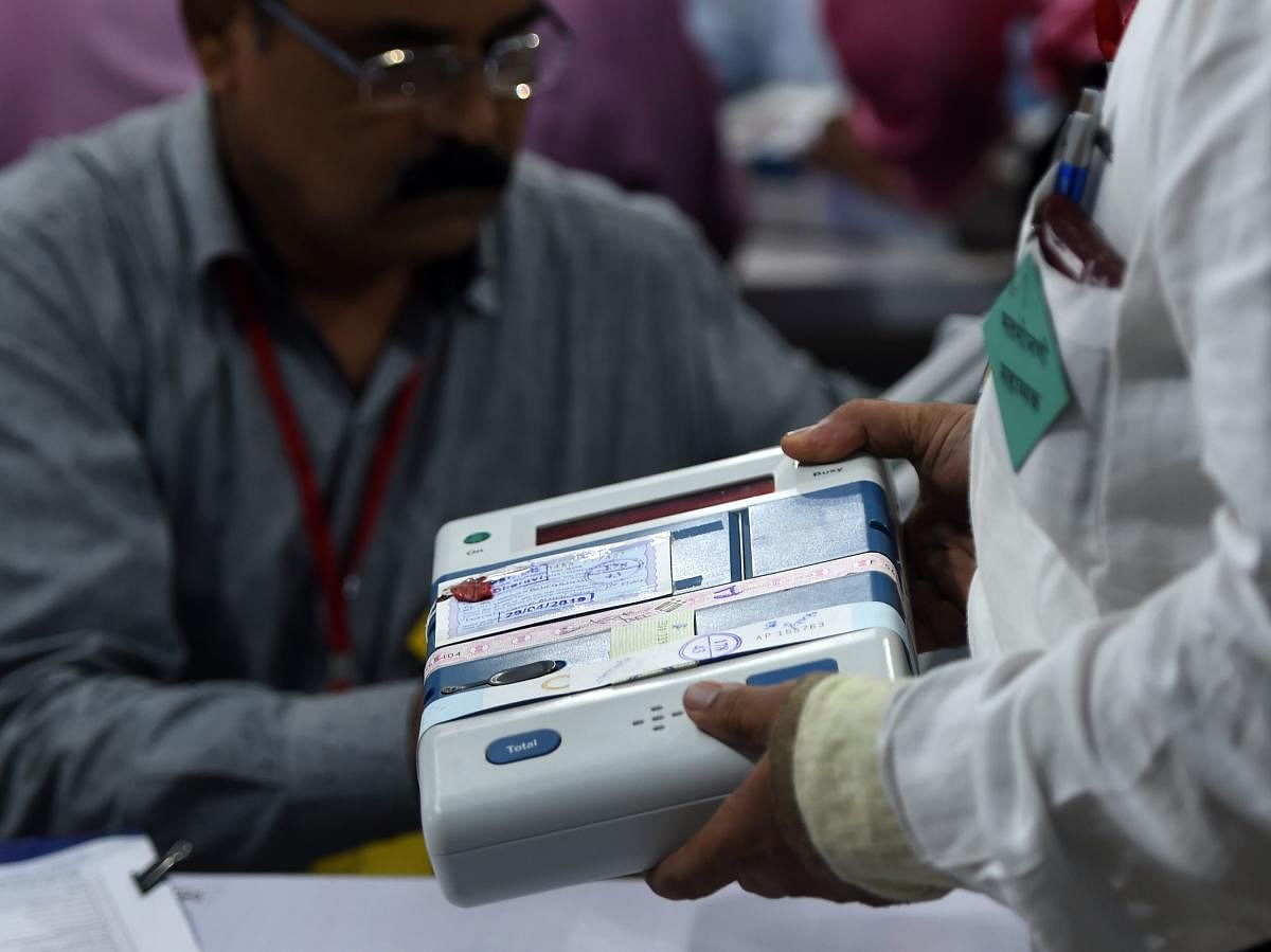 An Indian official inspects an Electronic Voting Machine (EVM) during a votes counting process at a booth in Mumbai (Photo AFP)