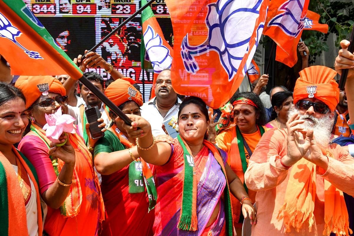 Supporters and party workers of Bharatiya Janata Party (BJP) dance and hold flags as they celebrate on the vote results day for general election in Bangalore.  AFP photo