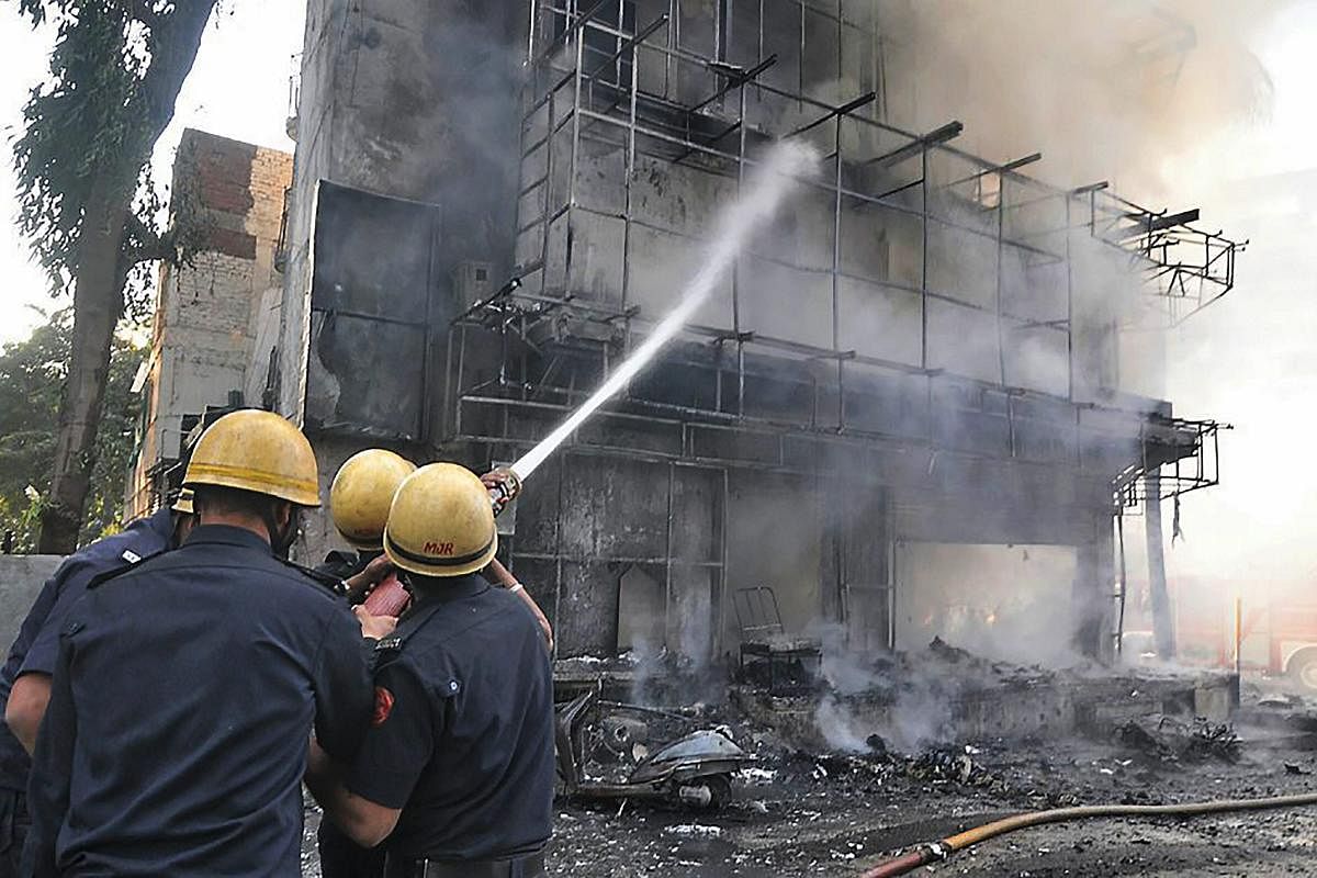 Surat: Fire fighters try to control fire at a shop in Surat on Friday. (PTI Photo)