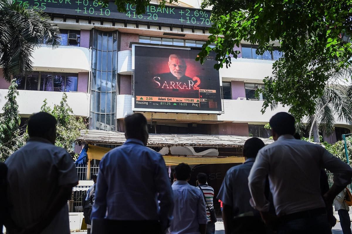 Mumbai: People look at the screen on BSE building as the sensex soars on the vote counting day for the 2019 Lok Sabha polls, in Mumbai, Thursday, May 23, 2019. (PTI Photo/Shashank Parade)