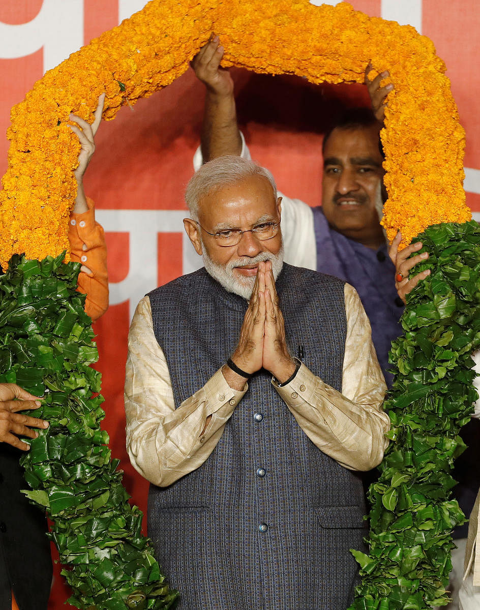 Indian Prime Minister Narendra Modi gestures as he is presented with a garland by Bharatiya Janata Party (BJP) leaders after the election results in New Delhi, India, May 23, 2019. REUTERS/Adnan Abidi
