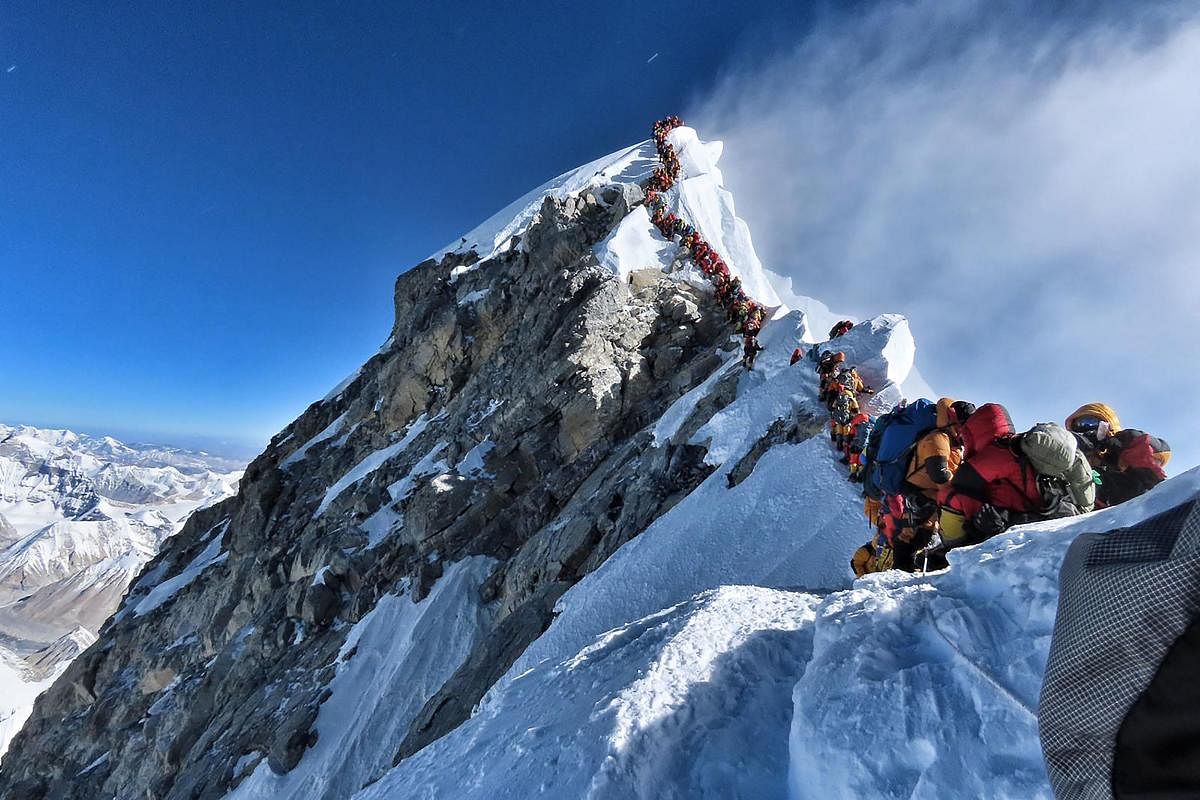 In this file handout photo taken on May 22, 2019 and released by climber Nirmal Purja's Project Possible expedition shows heavy traffic of mountain climbers lining up to stand at the summit of Mount Everest. - Three more climbers have died on Everest, exp