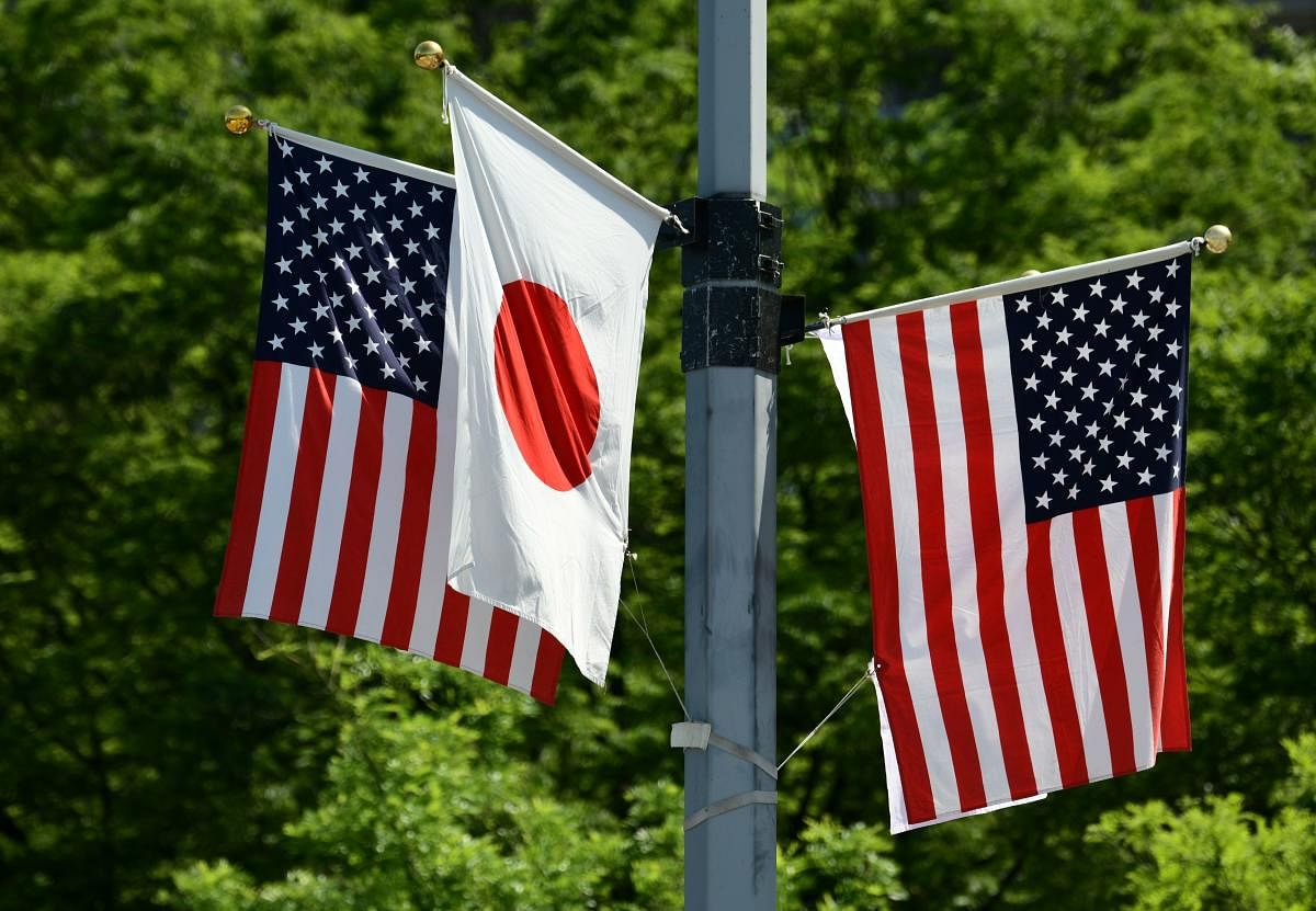 National flags of Japan and the US are displayed on a street in Tokyo on May 25, 2019. - US President Donald Trump will arrive in Japan on May 25 for a four-day trip likely to be dominated by warm words and friendly images, but light on substantive progre