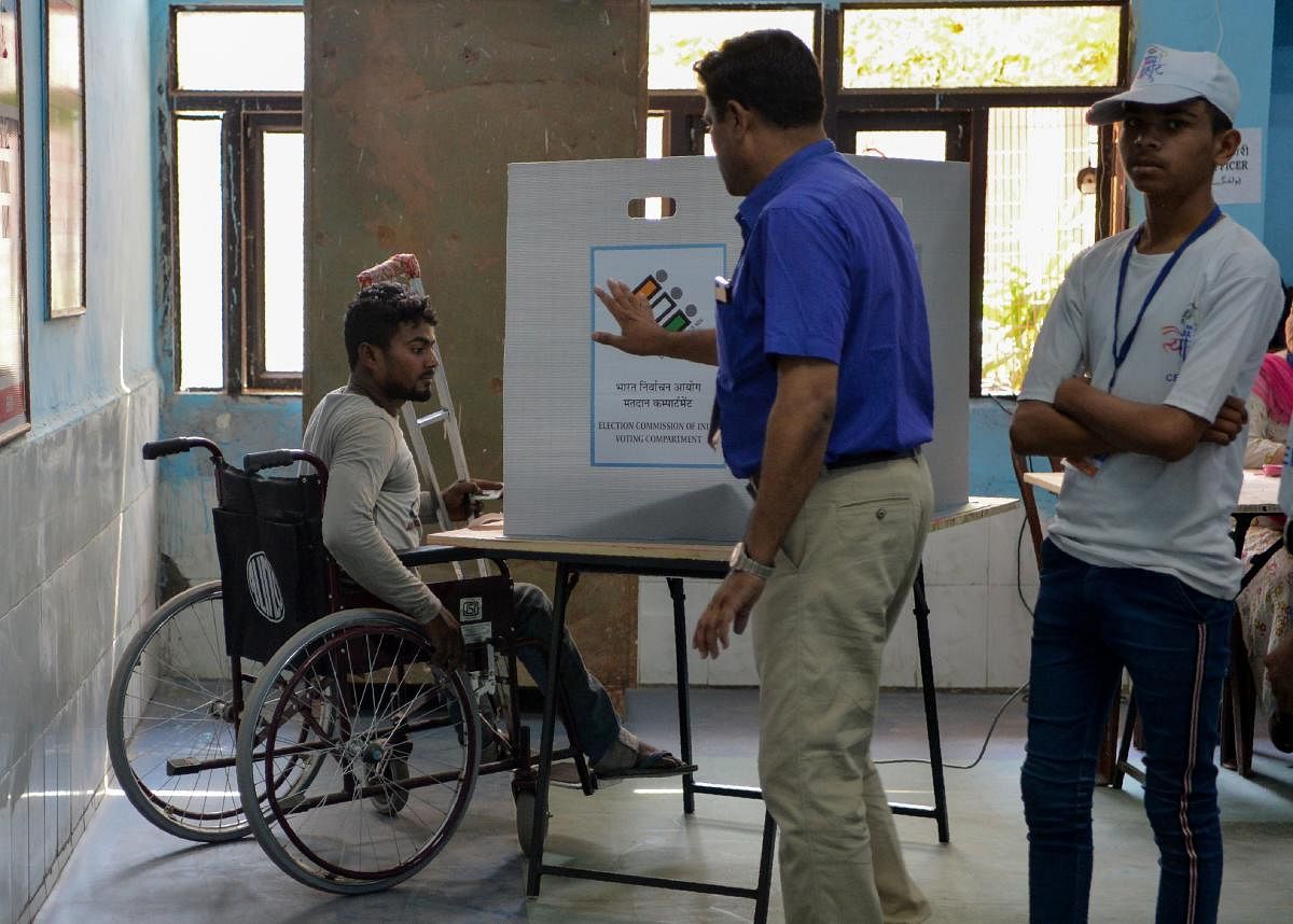 An Indian disabled man casts his vote at a polling station after the Election Commission of India ordered re-polling in Chandni Chowk in the old quarters of New Delhi on May 19, 2019. - (Photo by Sajjad HUSSAIN / AFP)