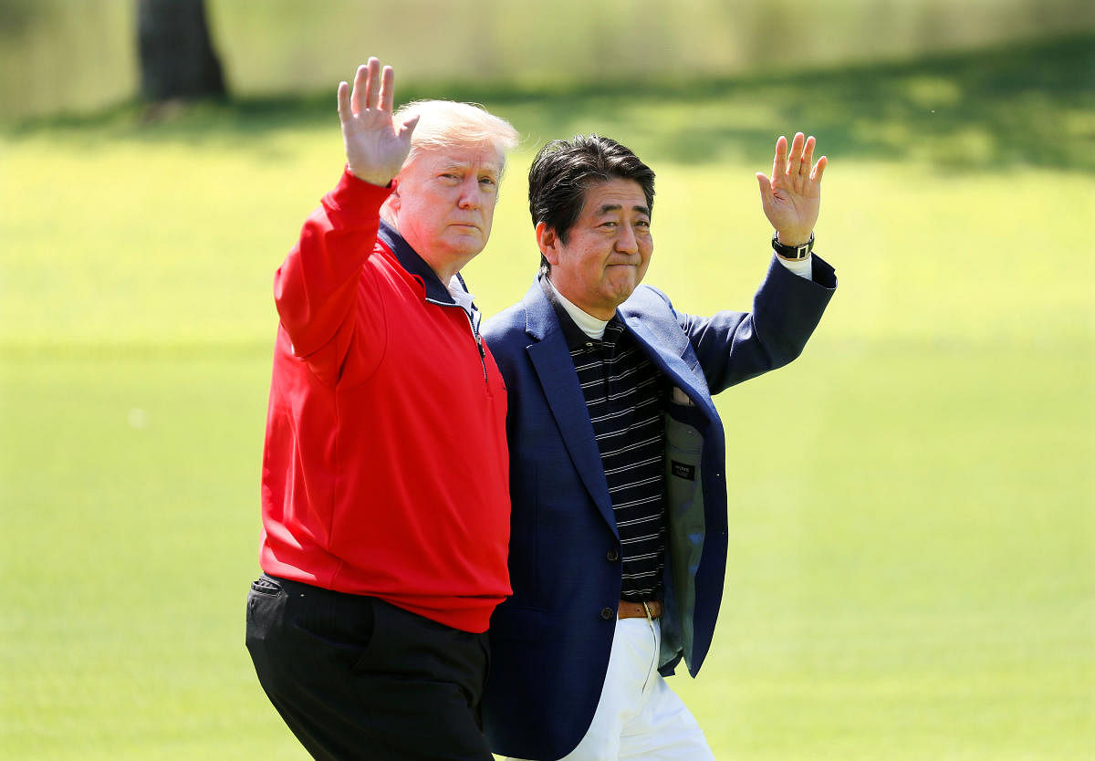 U.S. President Donald Trump and Japanese Prime Minister Shinzo Abe wave on the way to the course to play golf at Mobara Country Club in Mobara, Chiba Prefecture, east of Tokyo, Japan May 26, 2019. Kimimasa Mayama/Pool via Reuters