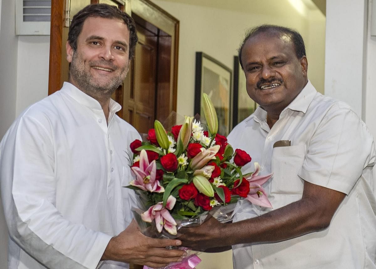 JD(S) leader and Karnataka chief minister-designate H D Kumaraswamy presents a bouquet to Congress President Rahul Gandhi. (Photo PTI)