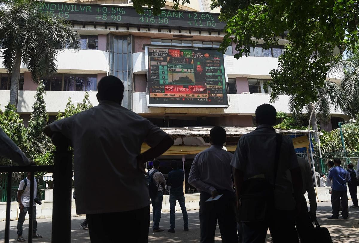 People watch share prices on a digital broadcast outside the Bombay Stock Exchange (BSE) (Photo AFP)