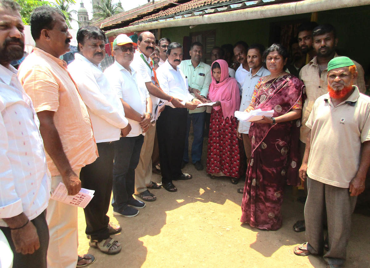 Malnad Area Development Board Chairman T D Raje Gowda takes part in a door-to-door campaign for the Town Panchayat election in N R Pura.