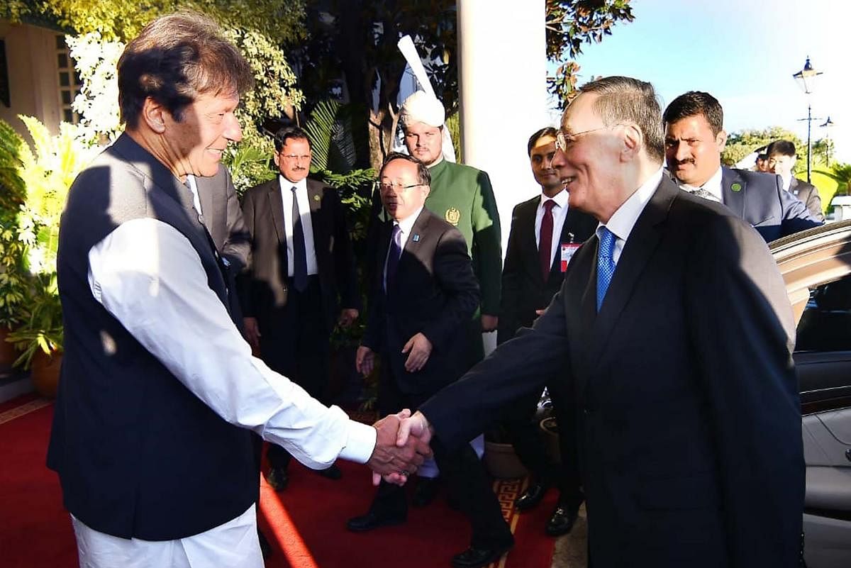 Pakistani Prime Minister Imran Khan (L) shakes hands with Chinese Vice President Wang Qishan on his arrival for a meeting in Islamabad on Sunday (Photo by Handout / PID / AFP)
