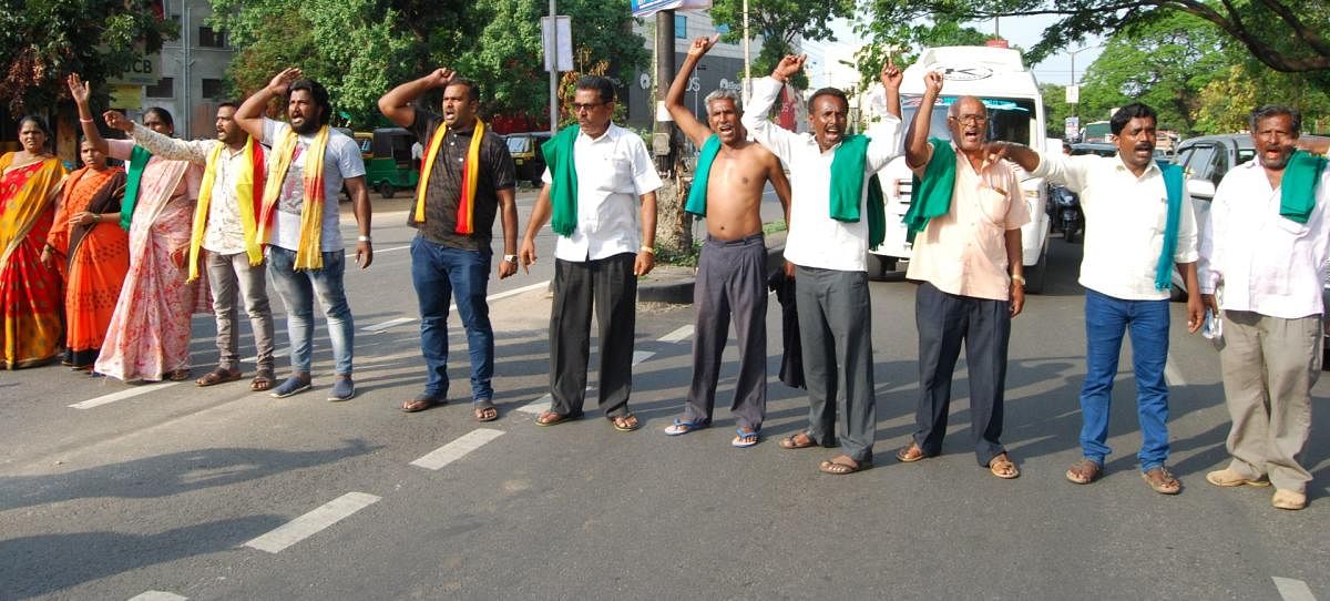 The activists of Raitha Sangha and Kannada Sene stage a protest, blocking the Bengaluru-Mysuru highway, in Mandya, on Tuesday. DH Photo