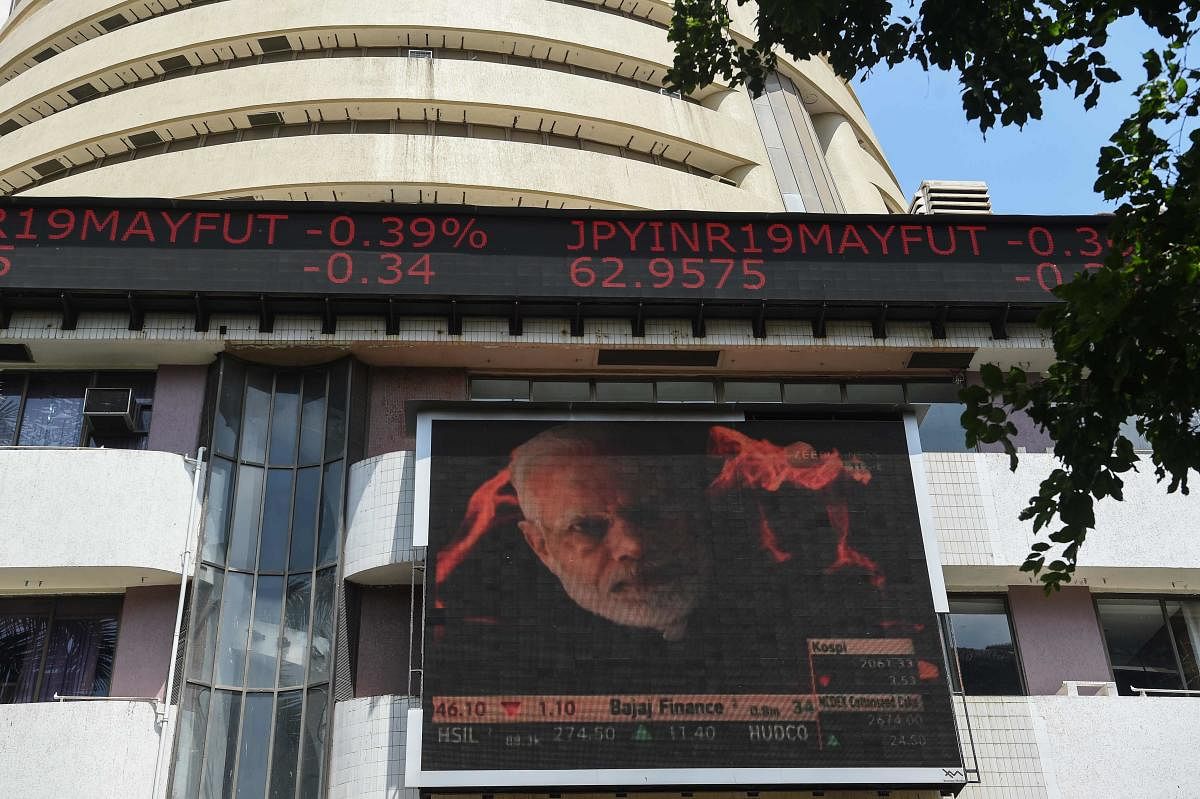A digital broadcast shows an image of Indian Prime Minister Narendra Modi next to stock prices outside the Bombay Stock Exchange (BSE) in Mumbai on May 23, 2019. - Indian stocks jumped to a record highs May 23 as early results in the world's biggest election showed Prime Minister Narendra Modi on course for a second term. (Photo by PUNIT PARANJPE / AFP)