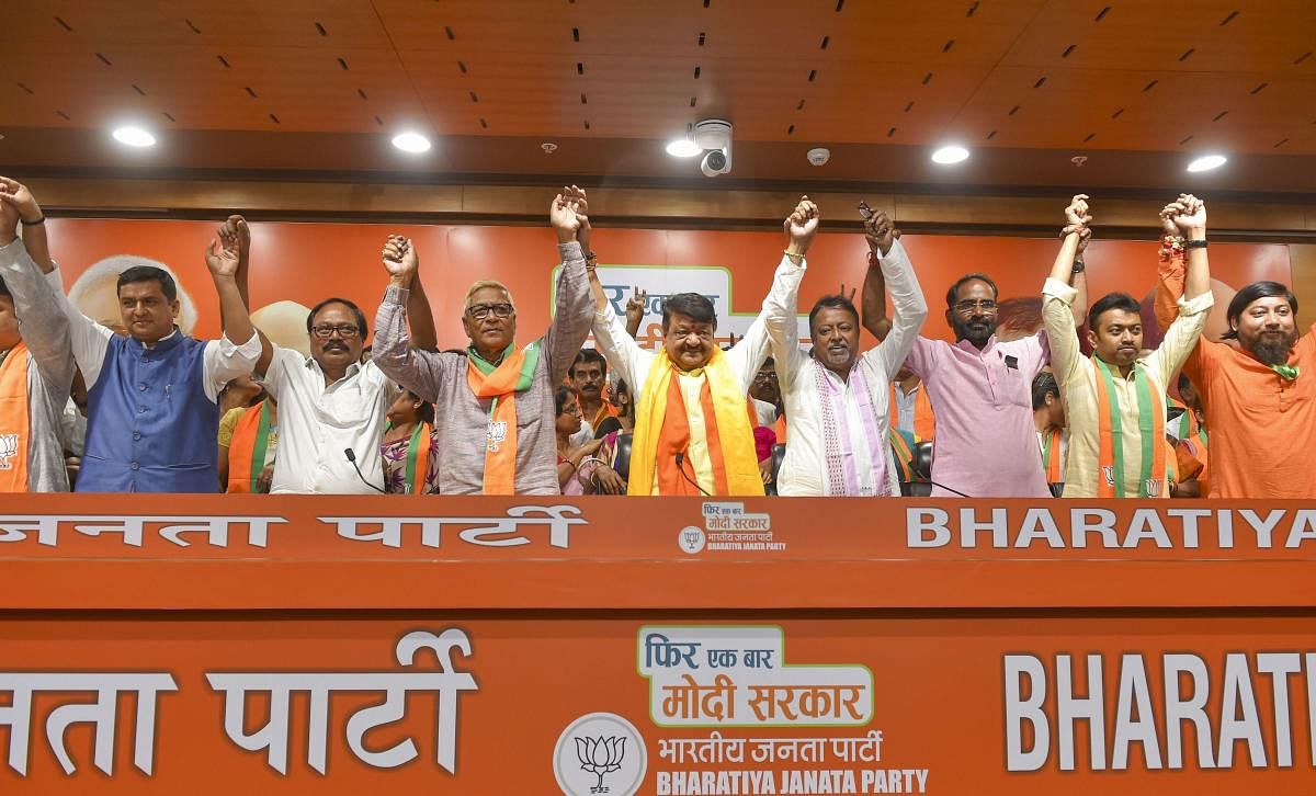 BJP leaders Kailash Vijaivargiya and Mukul Roy join hands with two Trinamool Congress and one CPM legislator, who joined Bharatiya Janata Party along with 60 councillors from three civic bodies in West Bengal, in New Delhi, Tuesday, May 28, 2019. (PTI Pho