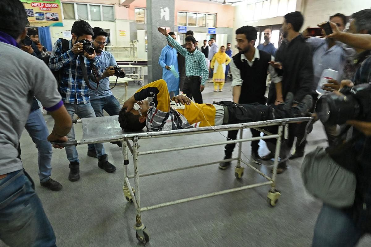 Volunteers and medical workers transport an injured youth on a stretcher after he was wounded by pellet-shot during clashes with government forces, at a hospital in Srinagar on May 29, 2019 (AFP)