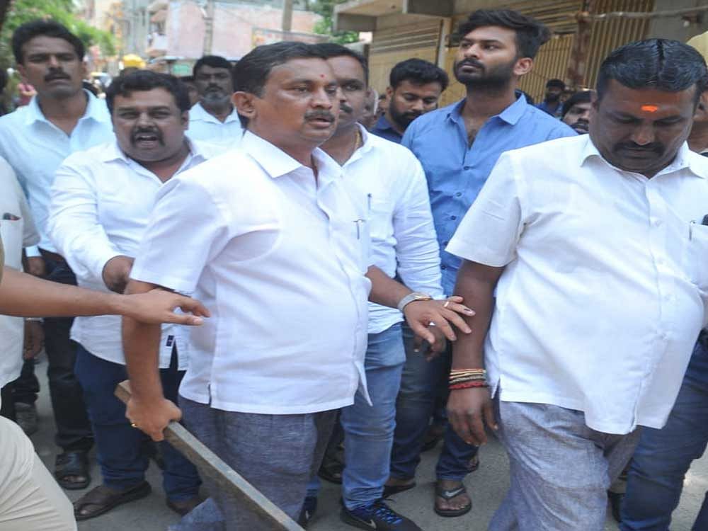 JD(S) leader Prakash seen holding an iron bar. DH photo