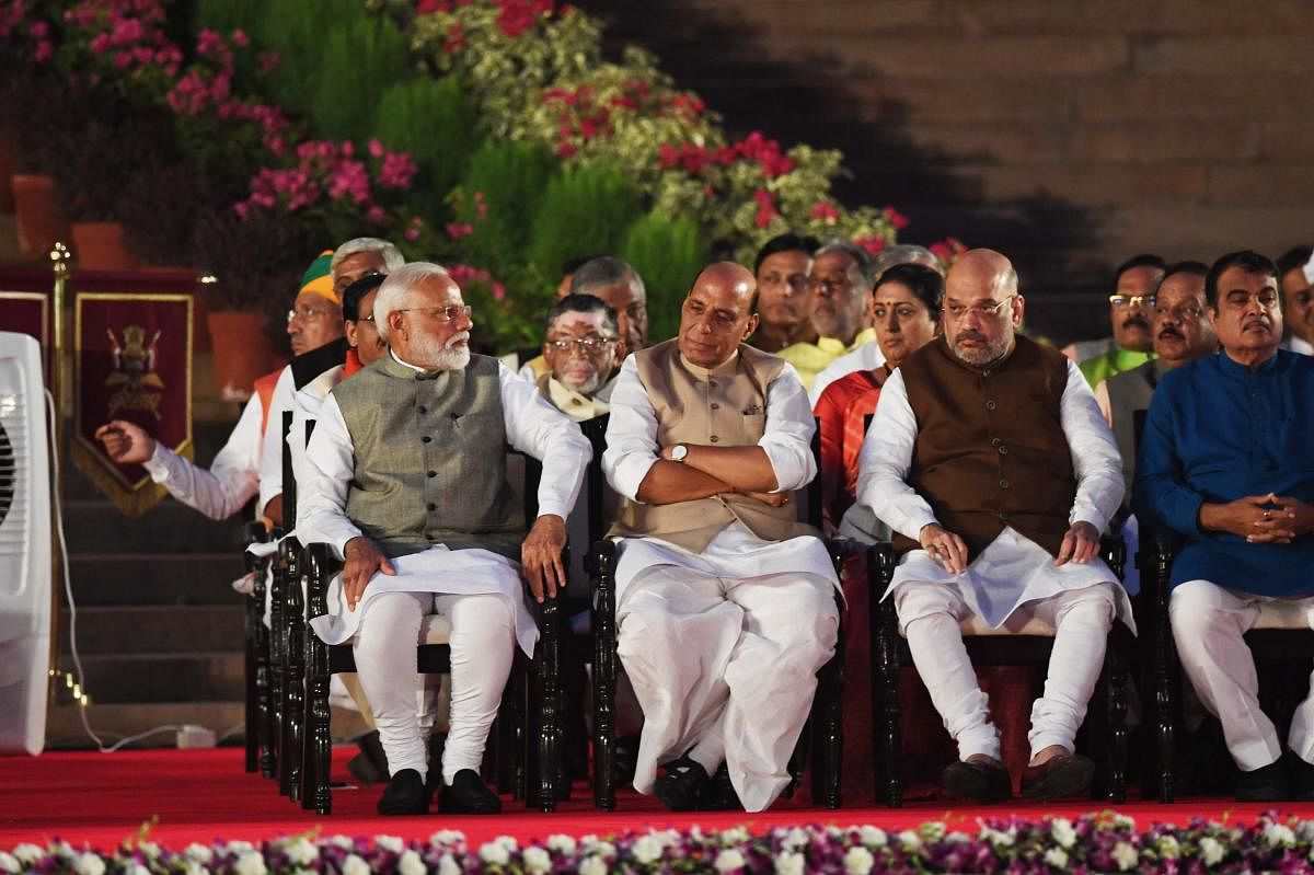 Newly sworn-in Indian Prime Minister Narendra Modi (L) looks on next to cabinet minister Rajnath Singh (2L) and Amit Shah after taking the oath of office at the President house in New Delhi. (AFP Photo)