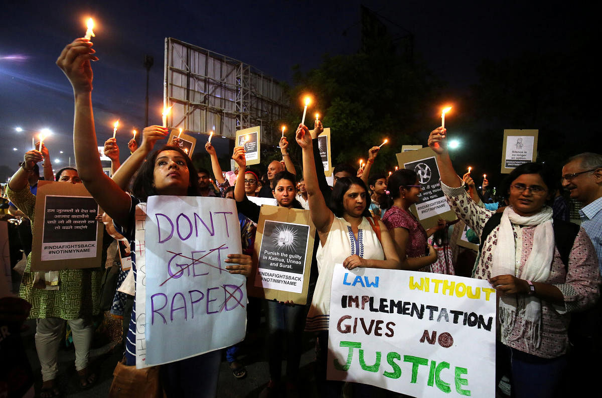 People hold candles and placards during a protest against the rape of an eight-year-old girl, in Kathua, near Jammu, a teenager in Unnao, Uttar Pradesh, and an eleven-year-old girl in Surat, Gujarat, in Ahmedabad, India, April 16, 2018. REUTERS file photo