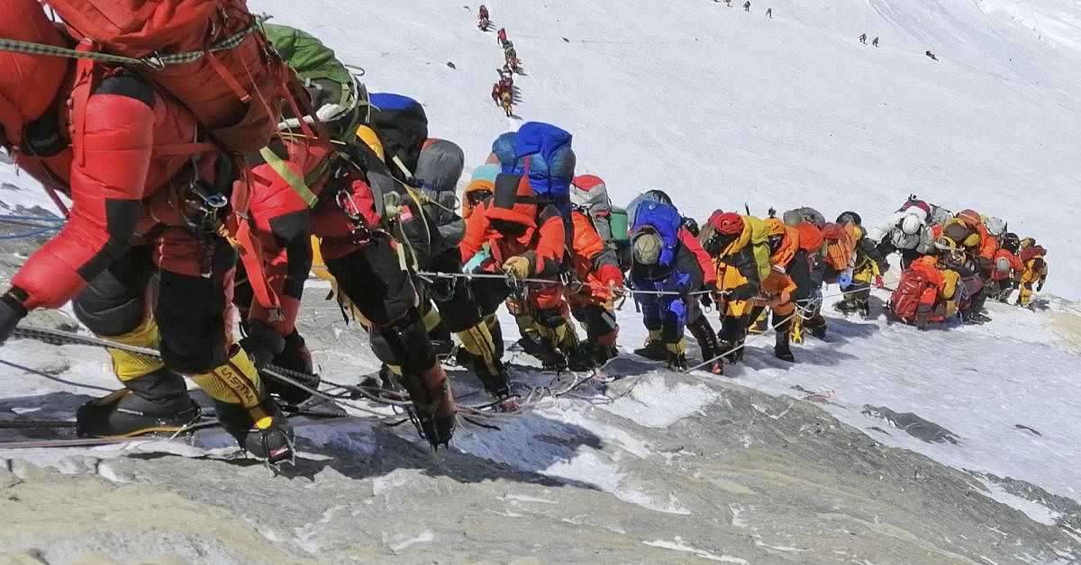 In this May 22, 2019 photo, a long queue of mountain climbers line a path on Mount Everest just below camp four, in Nepal. Seasoned mountaineers say the Nepal government's failure to limit the number of climbers on Mount Everest has resulted in dangerous