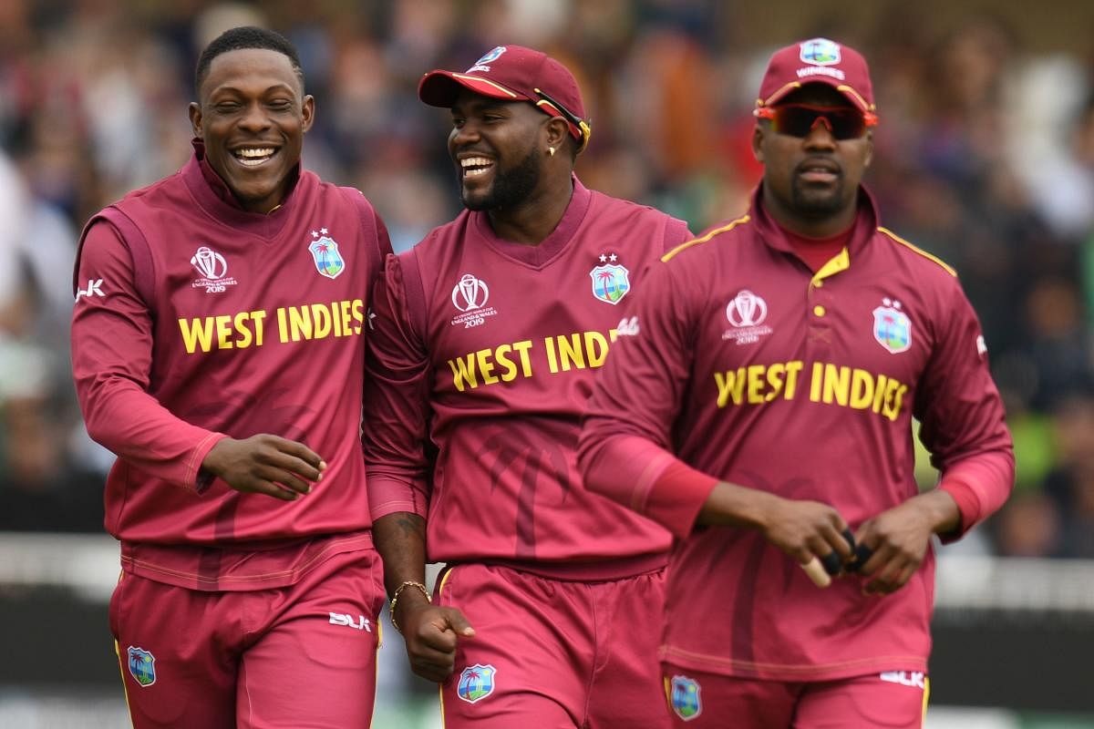West Indies' Ashley Nurse (2R), West Indies' Darren Bravo (R) and West Indies' Sheldon Cottrell (L) celebrate as they leave the field after dimissing Pakistan for 105 runs during the 2019 Cricket World Cup group stage match between West Indies and Pakista
