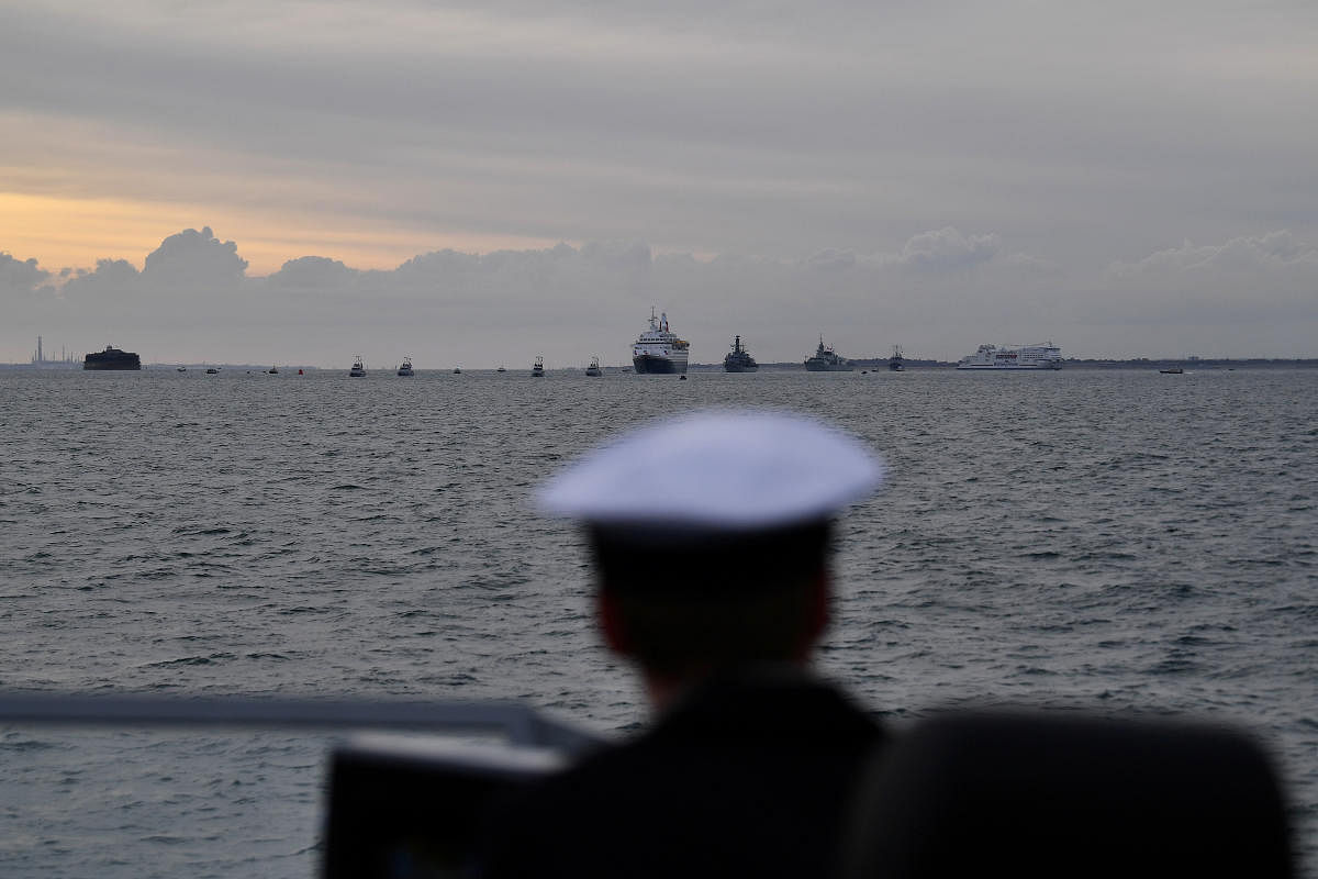 A sailor on board Example, a Royal Navy P2000 watches as the MV Boudicca, carrying veterans, leaves the harbour on its way to Normandy to commemorate the 75th anniversary of D-Day, in Portsmouth, Britain. Reuters