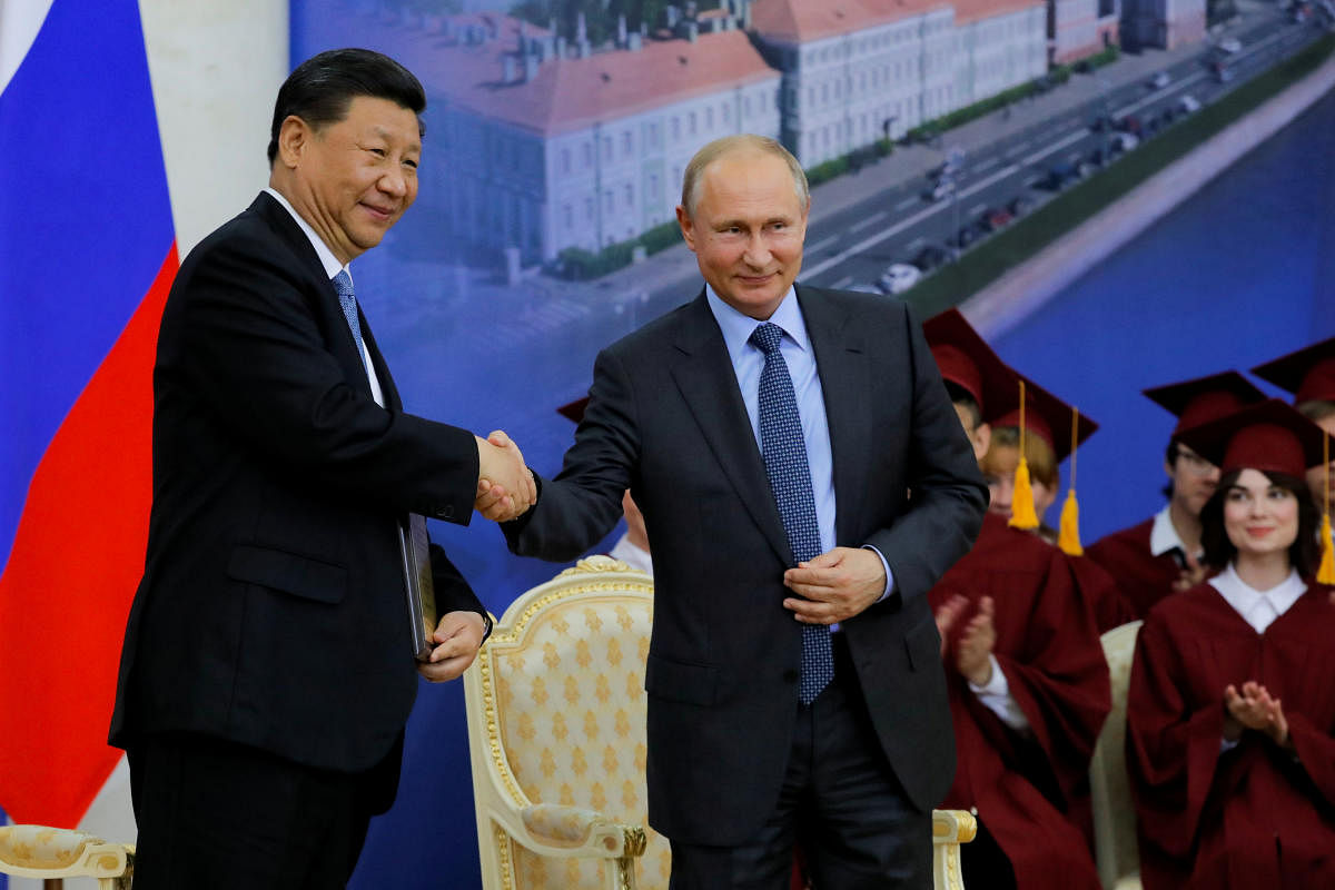 Chinese President Xi Jinping and Russian President Vladimir Putin shake hands during the ceremony of presenting Xi Jinping with a degree from the St. Petersburg State University at the St. Petersburg International Economic Forum (SPIEF) in St. Petersburg,