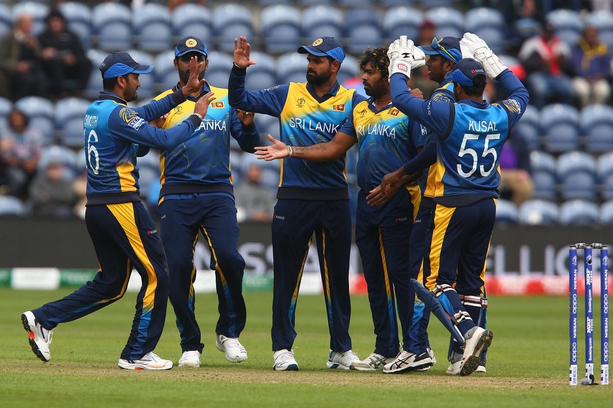Sri Lanka's Lasith Malinga (2R), Sri Lanka's captain Dimuth Karunaratne and teammates celebrate the wicket of Afghanistan's Mohammad Shahzad for seven during the 2019 Cricket World Cup. (AFP Photo)