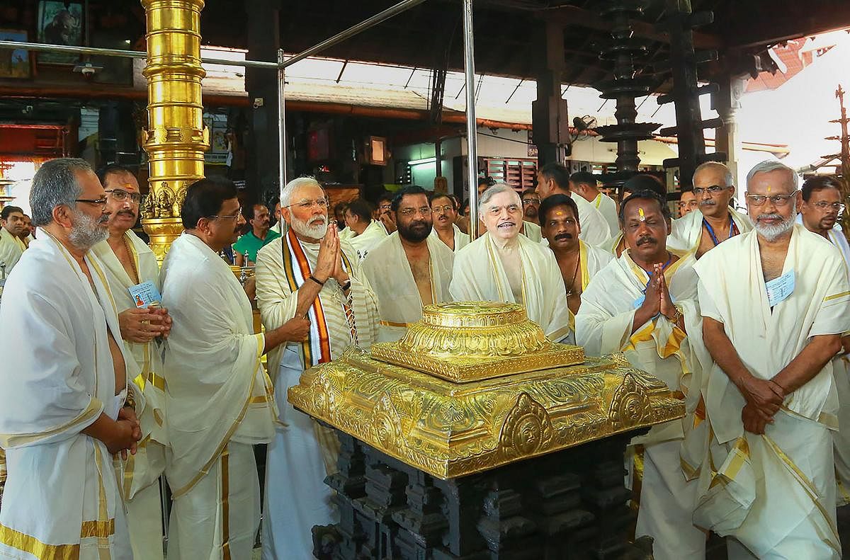 Prime Minister Narendra Modi accompanied by Kerala Governor P. Sathasivam, State Devasom Minister Kadakampally Surendran along with other senior Bharatiya Janata Party (BJP) leaders, offer their prayers at Lord Krishna temple in Guruvayur of Thrissur district. (PTI Photo)