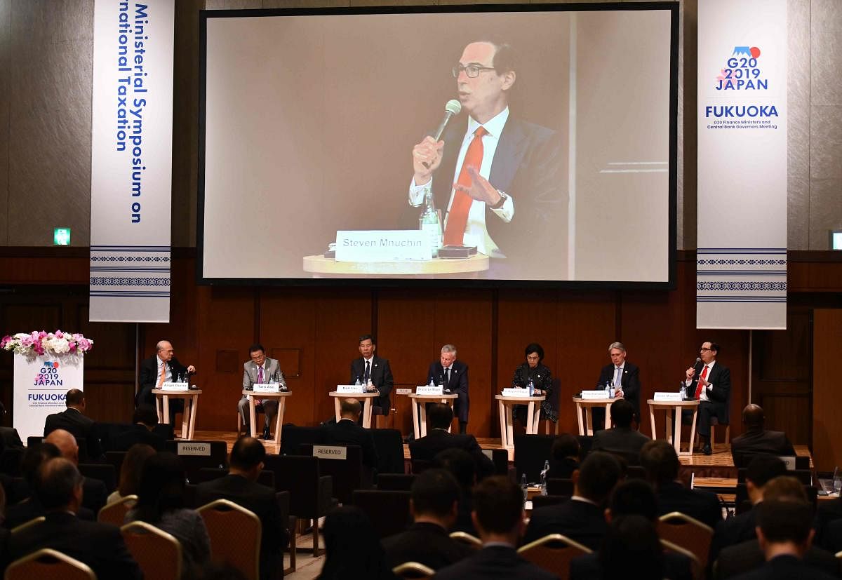 US Treasury Secretary Steven Mnuchin (far R and on video screen) delivers a speech during the G20 Ministerial Symposium on International Taxation at the G20 finance ministers and central bank governors meeting in Fukuoka on June 8, 2019. (Photo by Toshifumi KITAMURA and TOSHIFUMI KITAMURA / POOL / AFP)