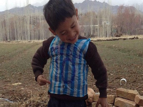 Photos of the boy wearing the improvised Messi jersey made from grocery bags discarded by their neighbour has touched a chord with football fans around the world. Image courtesy: Twitter