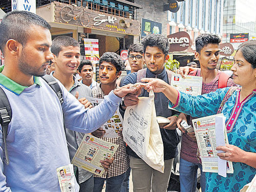 Students and volunteers create awareness on plastic ban on Church Street on Monday. DH PHOTO