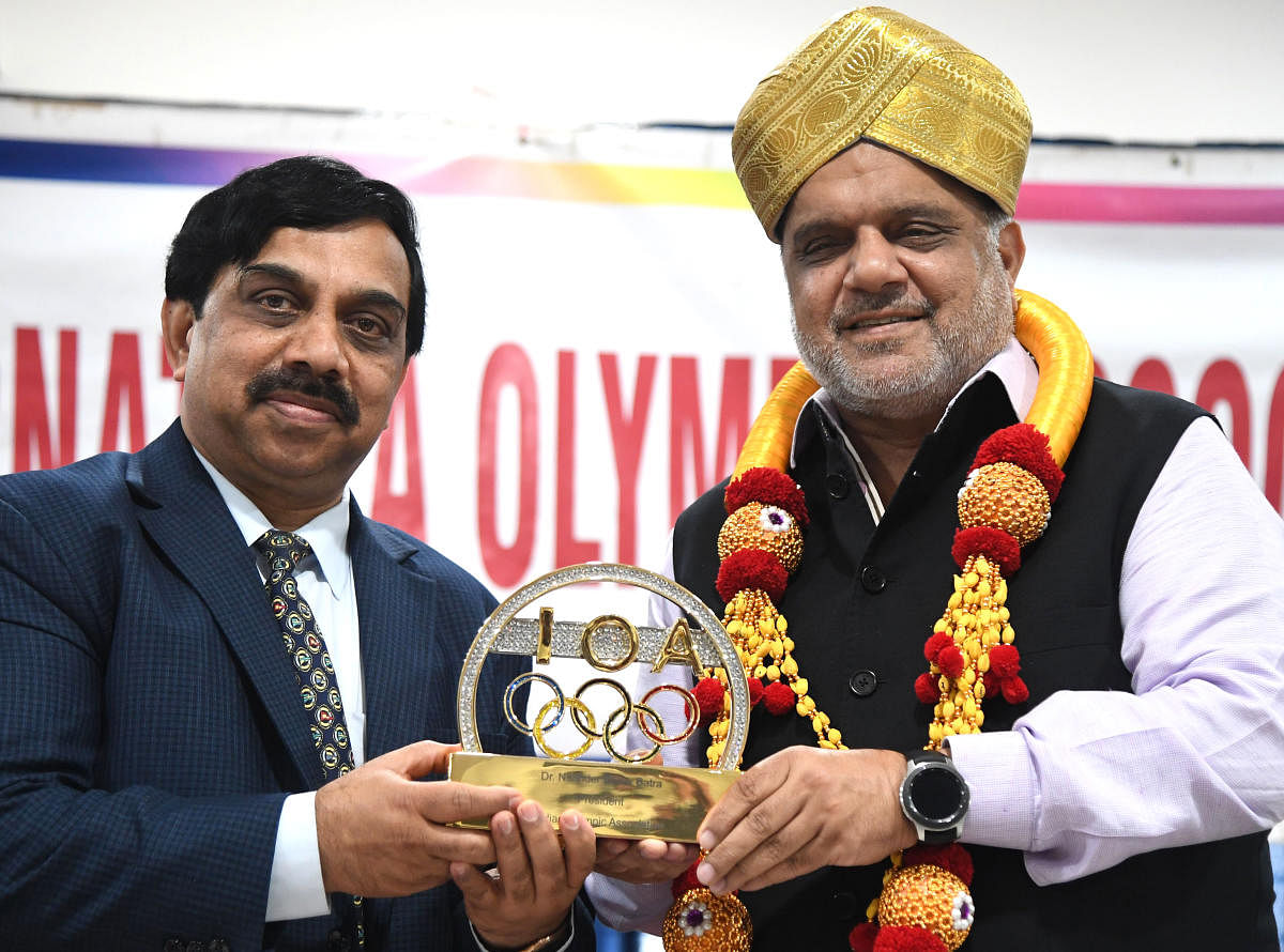 IOA President Narinder Batra (right) presents a memento to Karnataka Olympic Association President K Govindaraj in Bengaluru on Saturday. DH Photo