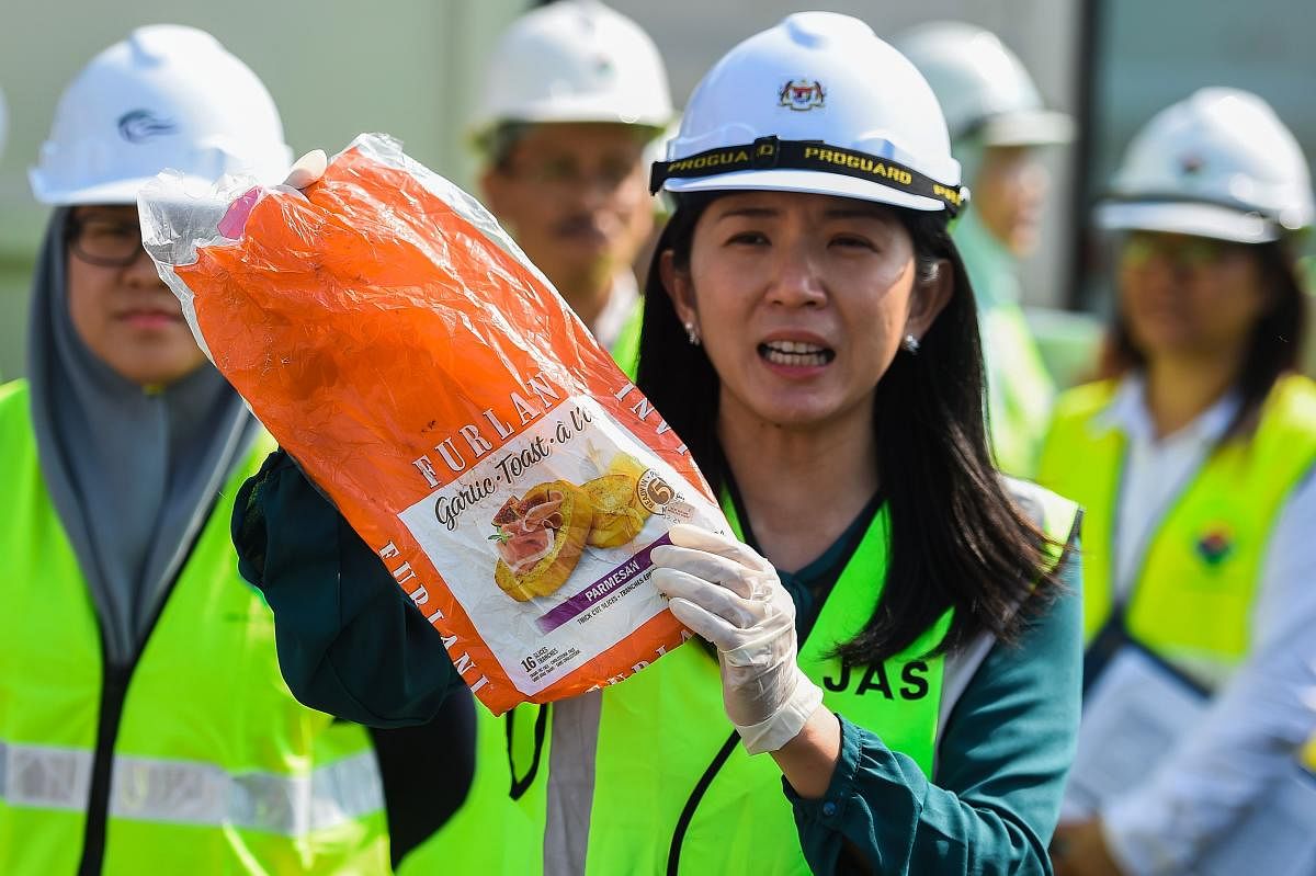Malaysia's Minister of Energy, Science, Technology, Environment and Climate Change (MESTECC), Yeo Bee Yin (C) shows a sample of plastic waste shipment before sending back to the country of origin in Port Klang, west of Kuala Lumpur on May 28, 2019. (Photo