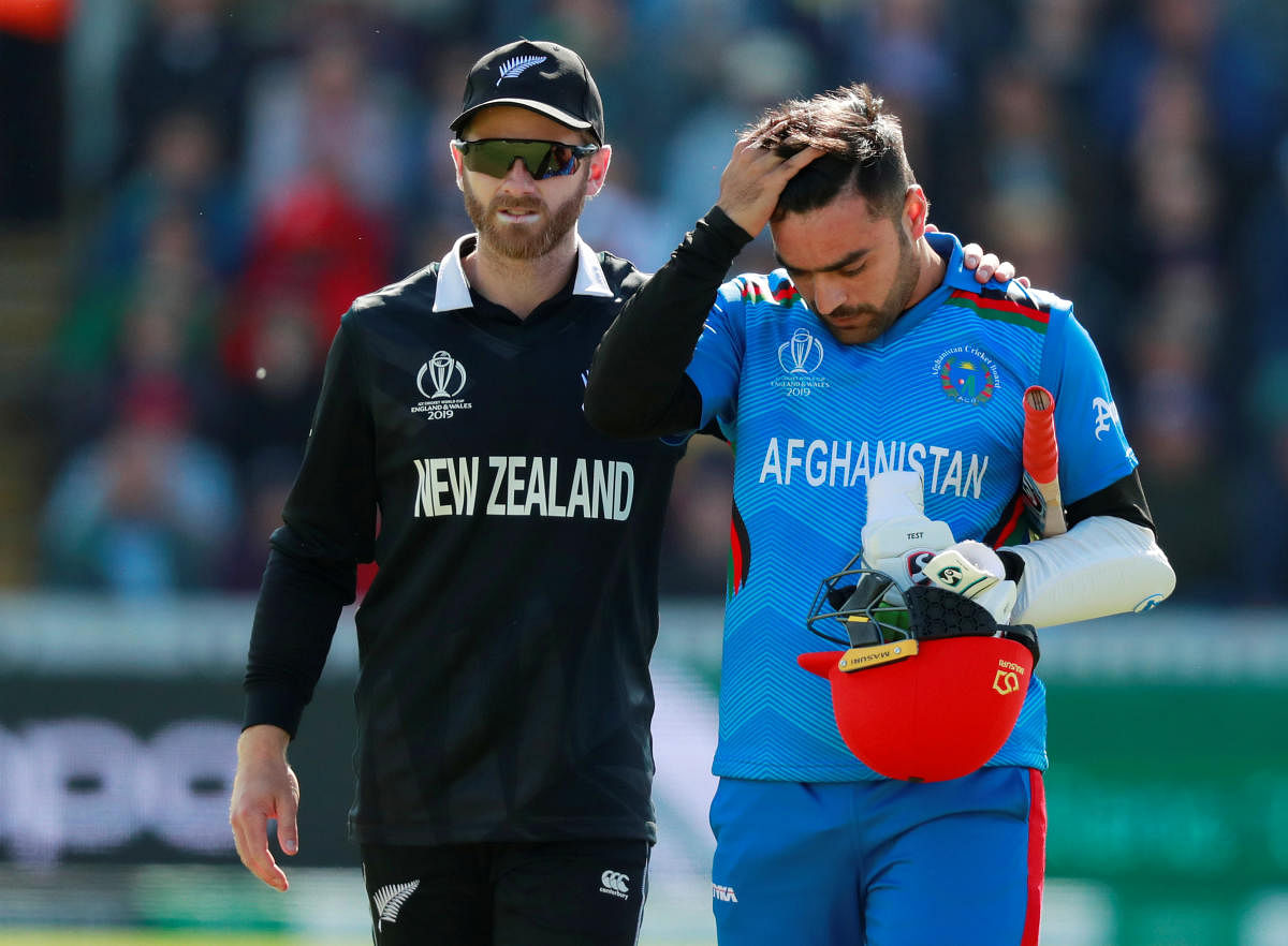 SHAKEN UP: New Zealand's Kane Williamson helps Afghanistan's Rashid Khan after he was hit on his head by pacer Lockie Ferguson. Reuters 