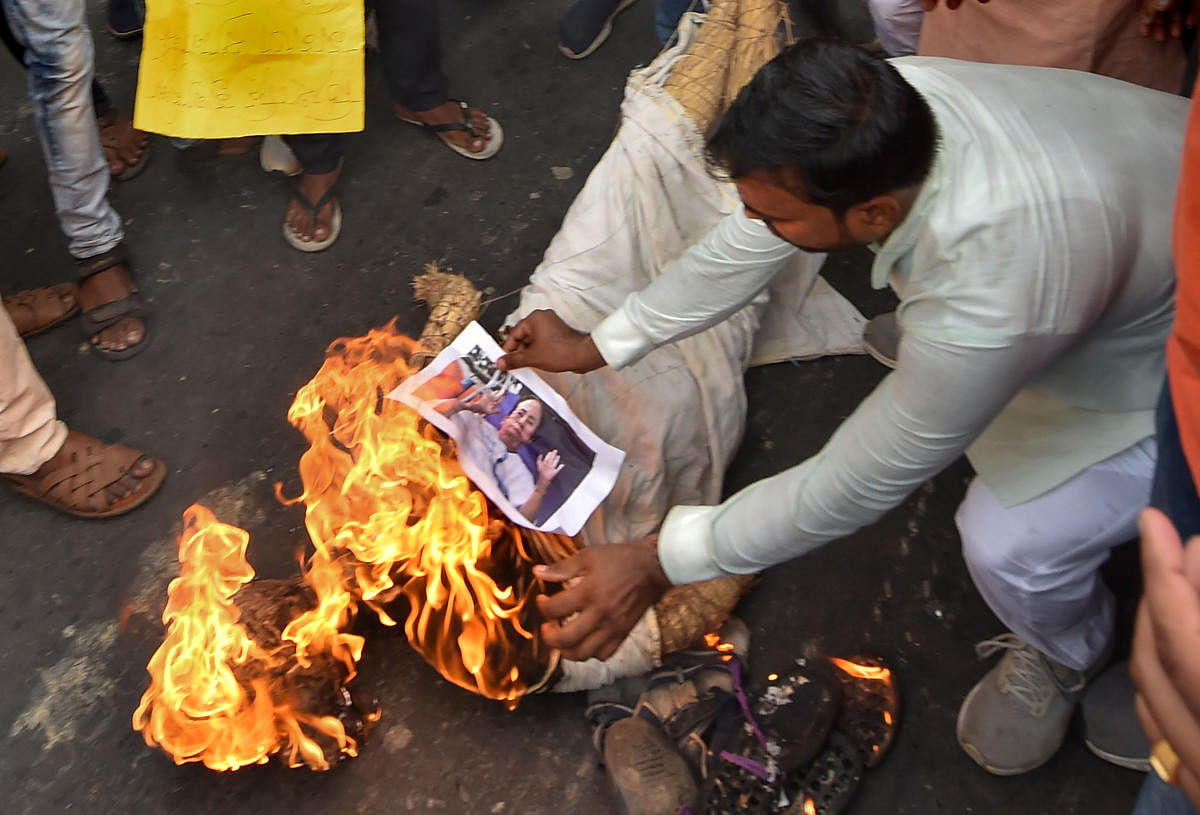 BJP workers burn a photograph of Chief Minister Mamata Banerjee during a protest against alleged failure of law and order situation, and killing of the party workers in the various districts of West Bengal, in Kolkata, Sunday, June 9, 2019. (PTI Photo/Ashok Bhaumik) 
