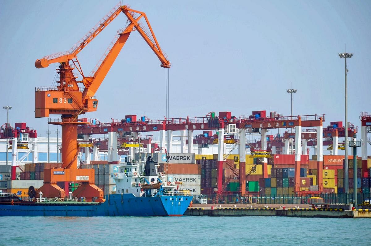 A crane transfers goods at a port in Qingdao, in China's eastern Shandong province on June 10, 2019. (Photo by STR / AFP) / China OUT