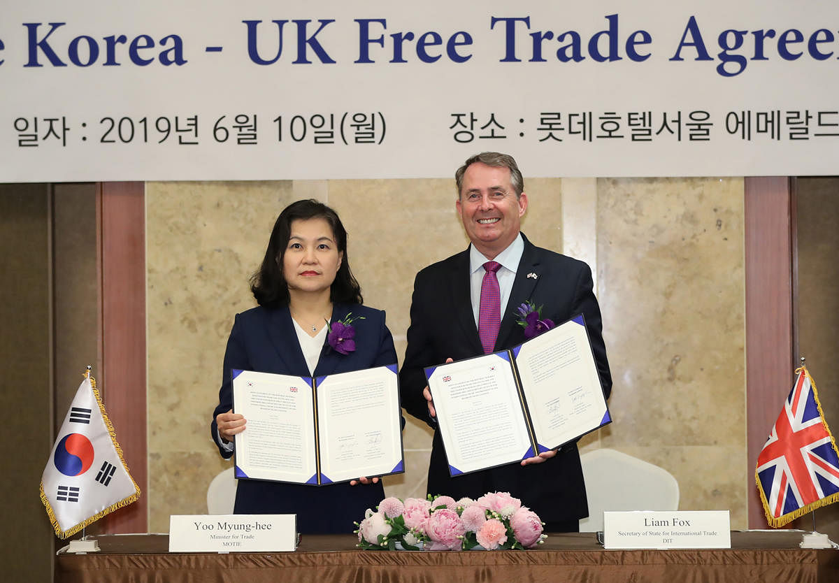 South Korea's Trade Minister Yoo Myung-hee (L) poses with Britain's International Trade Secretary Liam Fox (R) during a signing ceremony of an in-principle South Korea-UK free trade agreement in Seoul. (AFP File Photo)