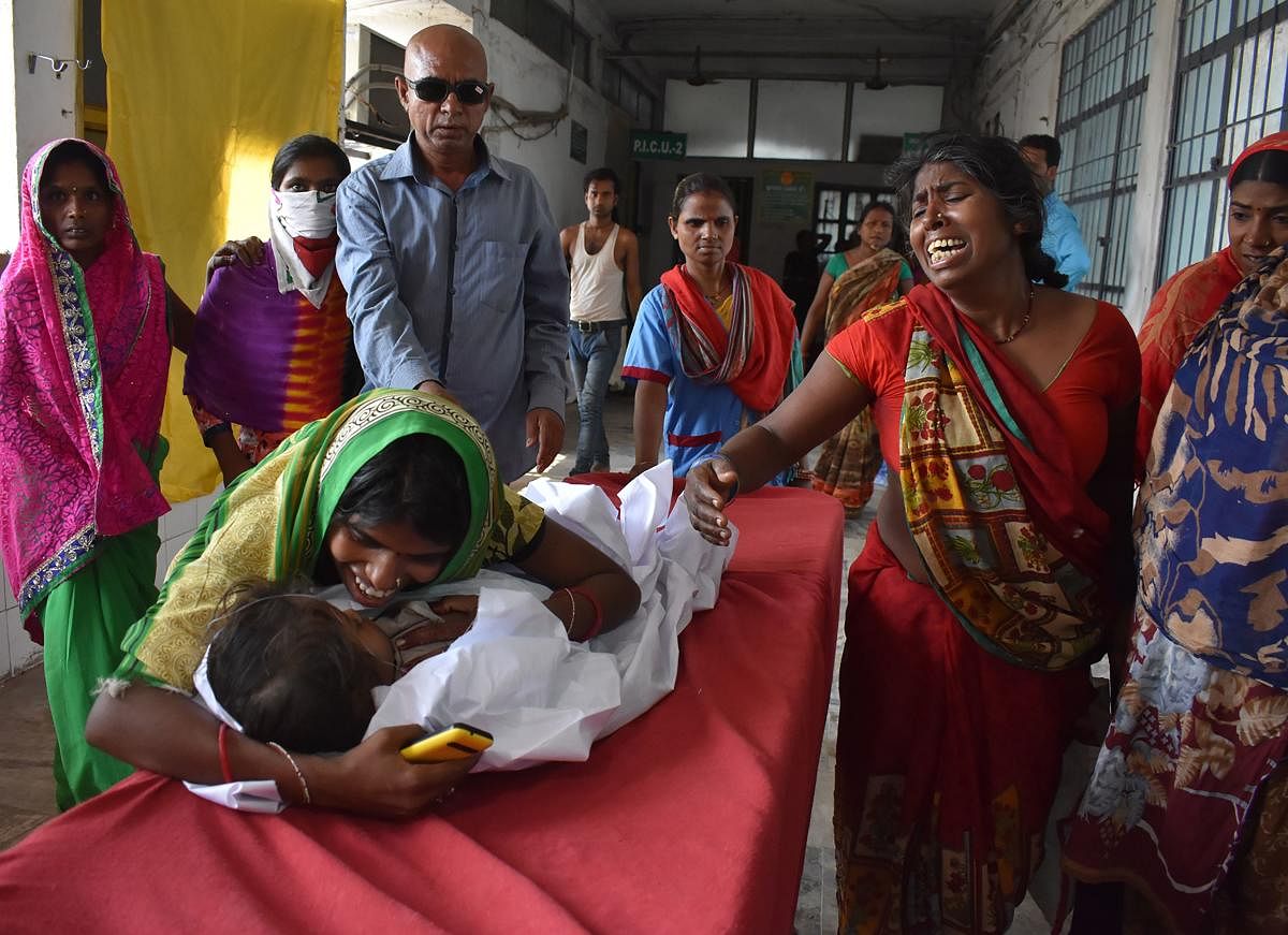 An Indian child arrives in a hospital due to Acute Encephalitis Syndrome (AES) as family members react in Muzaffarpur on June 10, 2019. - At least 14 children have died due to Acute Encephalitis Syndrome (AES) while over a dozen are admitted in hospitals.