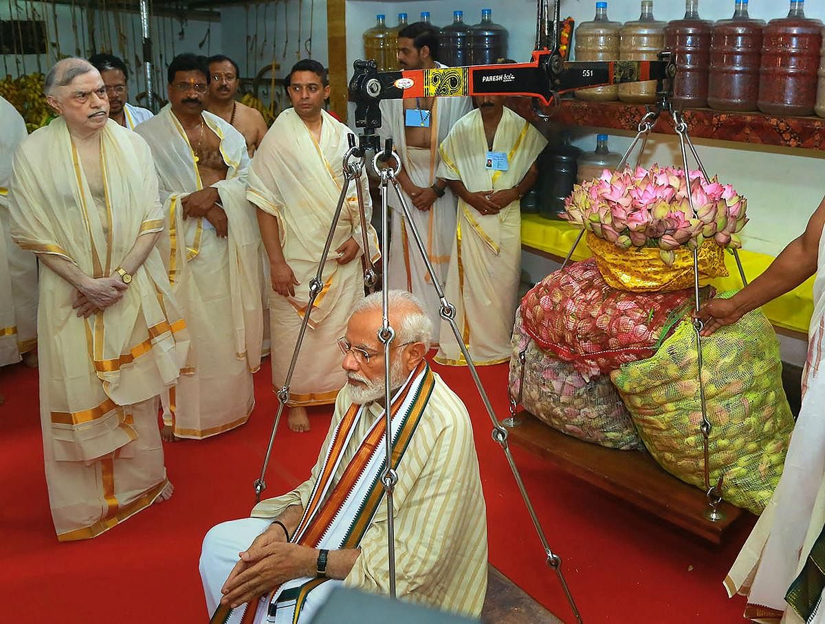 Prime Minister Narendra Modi weighed against lotus flowers as he offers his prayers at Lord Krishna temple in Guruvayur of Thrissur district, Saturday. PTI photo