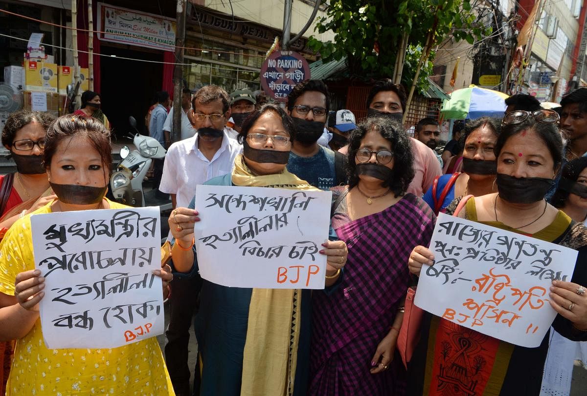 Indian supporters of the Bharatiya Janata Party (BJP) hold placards as they observe 'Black day' during a silent protest rally against the recent killings at Sandeshkhali in West Bengal, in Siliguri on June 10, 2019. (Photo by AFP)