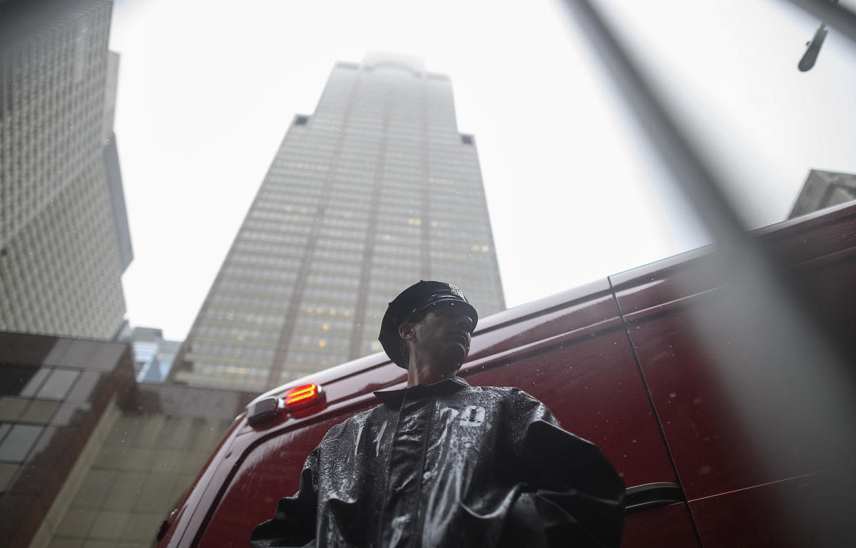 A policeman stands in front of the building where a helicopter crash-landed on top in midtown Manhattan in New York on June 10, 2019. - The crash started a fire and left one person dead as the entire building shook from the impact. AFP