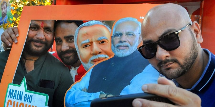 Supporters take selfies with a picture of Prime Minister Narendra Modi as they take part in an event of 'Main Bhi Chowkidar' campaign in Amritsar Monday April 1 2019. | PTI
