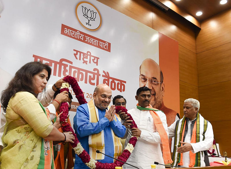 Union Home Minister and BJP president Amit Shah being garlanded at a party meeting in New Delhi on Thursday. (PTI Photo)