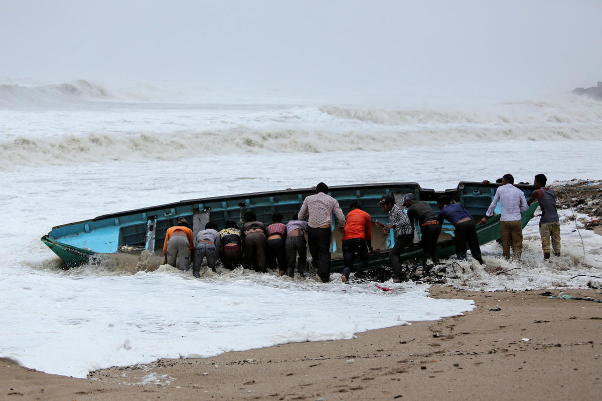 Fishermen move a fishing boat to a safer place along the shore ahead of Cyclone Vayu in Veraval, India, June 13, 2019. (Reuters Photo)