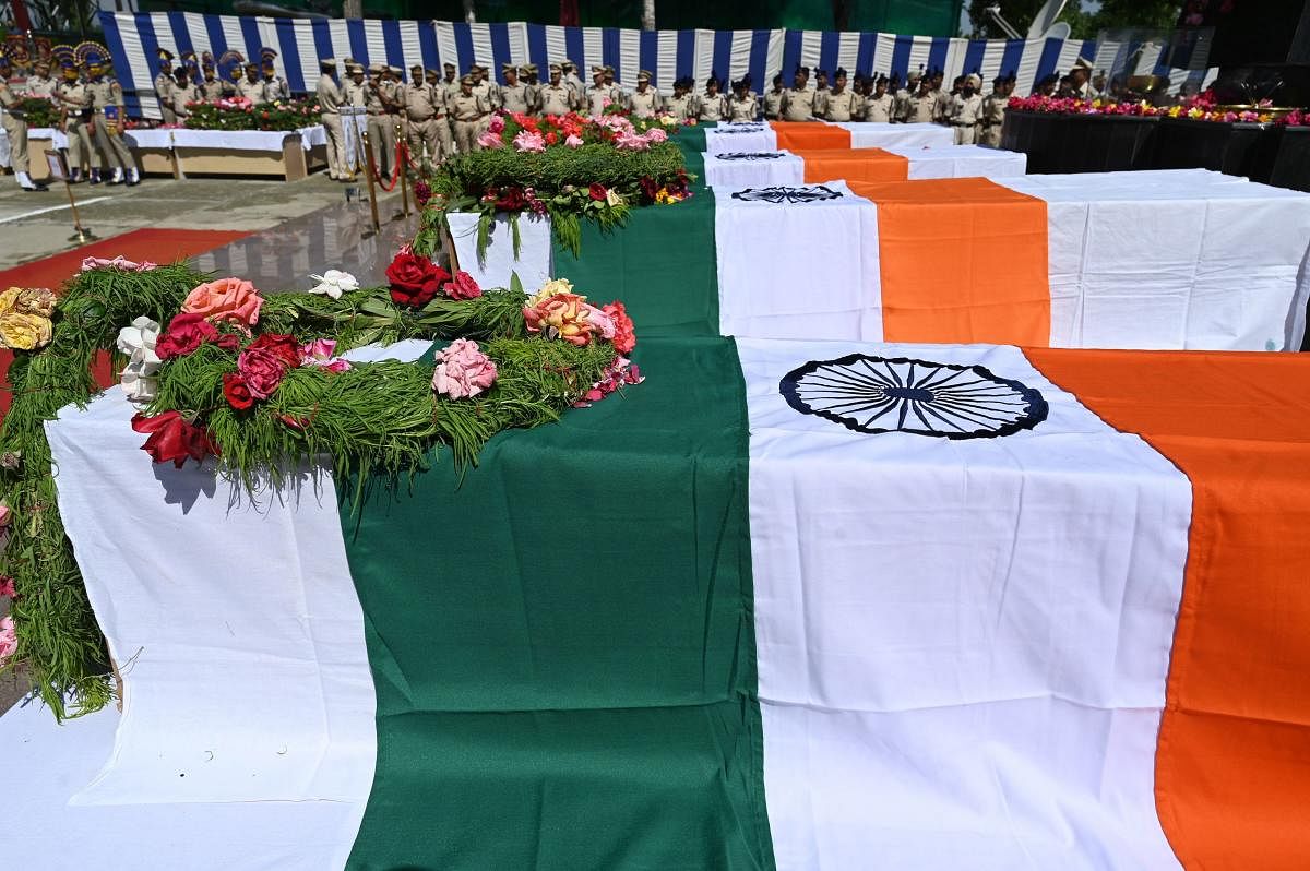 Indian paramilitary troopers stand next to flag-wrapped coffins with the bodies of slain colleague during a wreath-laying ceremony at a paramilitary camp in Srinagar on June 13, 2019. (Photo by AFP)