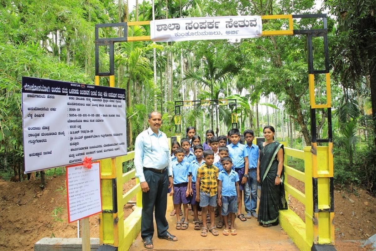Schoolchildren stand on a bridge constructed under the ‘Shaala Samparka Sethu’ programme at Kunturumajalu in Kadaba taluk.