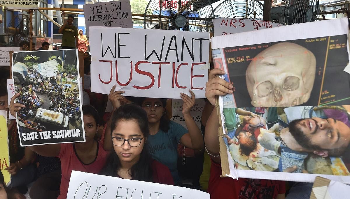 Junior doctors hold placards during a demonstration after an intern doctor was attacked and seriously injured over the death of a 75-year-old patient, at Nil Ratan Sircar Medical College and Hospital, in Kolkata. (PTI Photo)