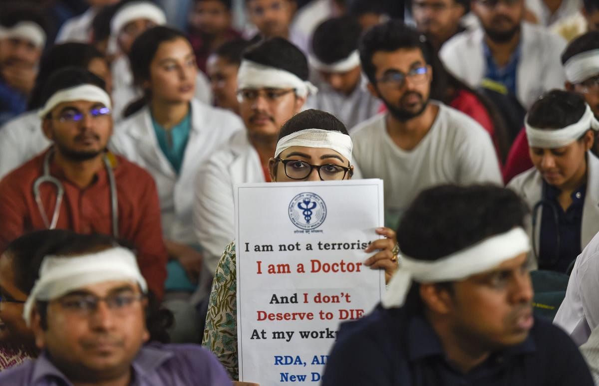 Members of Resident Doctors Association (RDA) of AIIMS wearing bandages on their heads protest to show solidarity with their counterparts in West Bengal, who stopped work on Tuesday protesting against the assault on their colleagues, in New Delhi. (PTI Ph