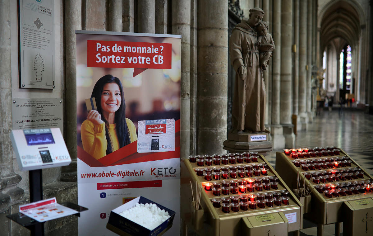 A card machine allowing people to pay without cash for votive candles is seen inside the Cathedral of Notre-Dame in Amiens, France, June 13, 2019. (REUTERS)
