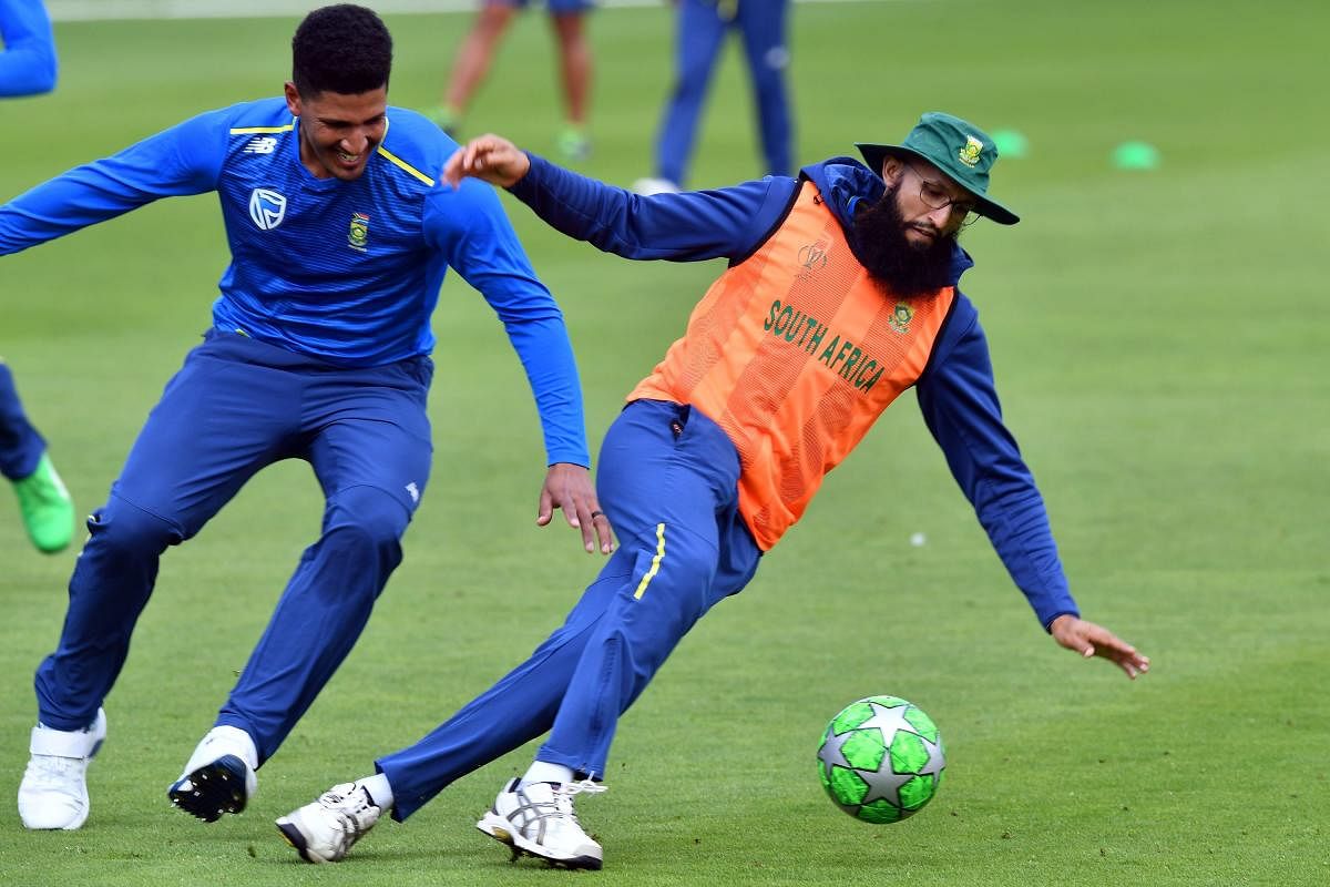 South Africa player Hashim Amla (R) attends a training session at Sophia Gardens Glamorgan Cricket Ground, South Wales on June 13, 2019, ahead of their 2019 World Cup match against Afghanistan. (Photo by Saeed KHAN / AFP)
