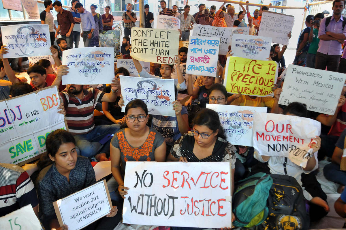 Junior doctors hold placards during their strike in protest against an attack on an intern doctor, at Nil Ratan Sircar Medical College and Hospital in Kolkata, Friday, June 14, 2019. (PTI Photo)