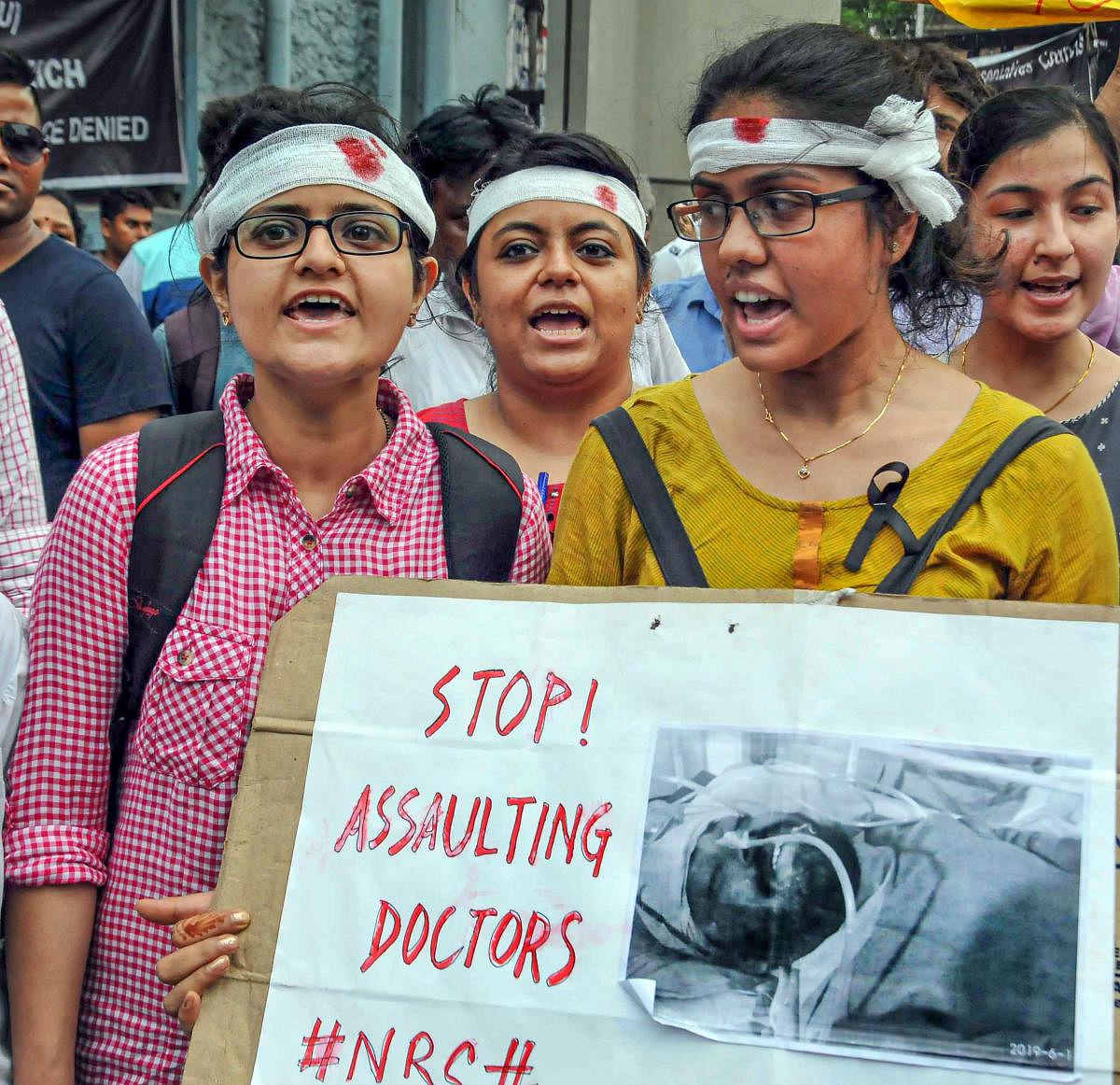 Doctors wear bandages on their heads a sign of protest as they participate in a rally to show solidarity during the strike to protest against an attack on intern junior doctor, at Nil Ratan Sircar Medical College &amp; Hospital, in Kolkata on Saturday. (PTI File Photo)